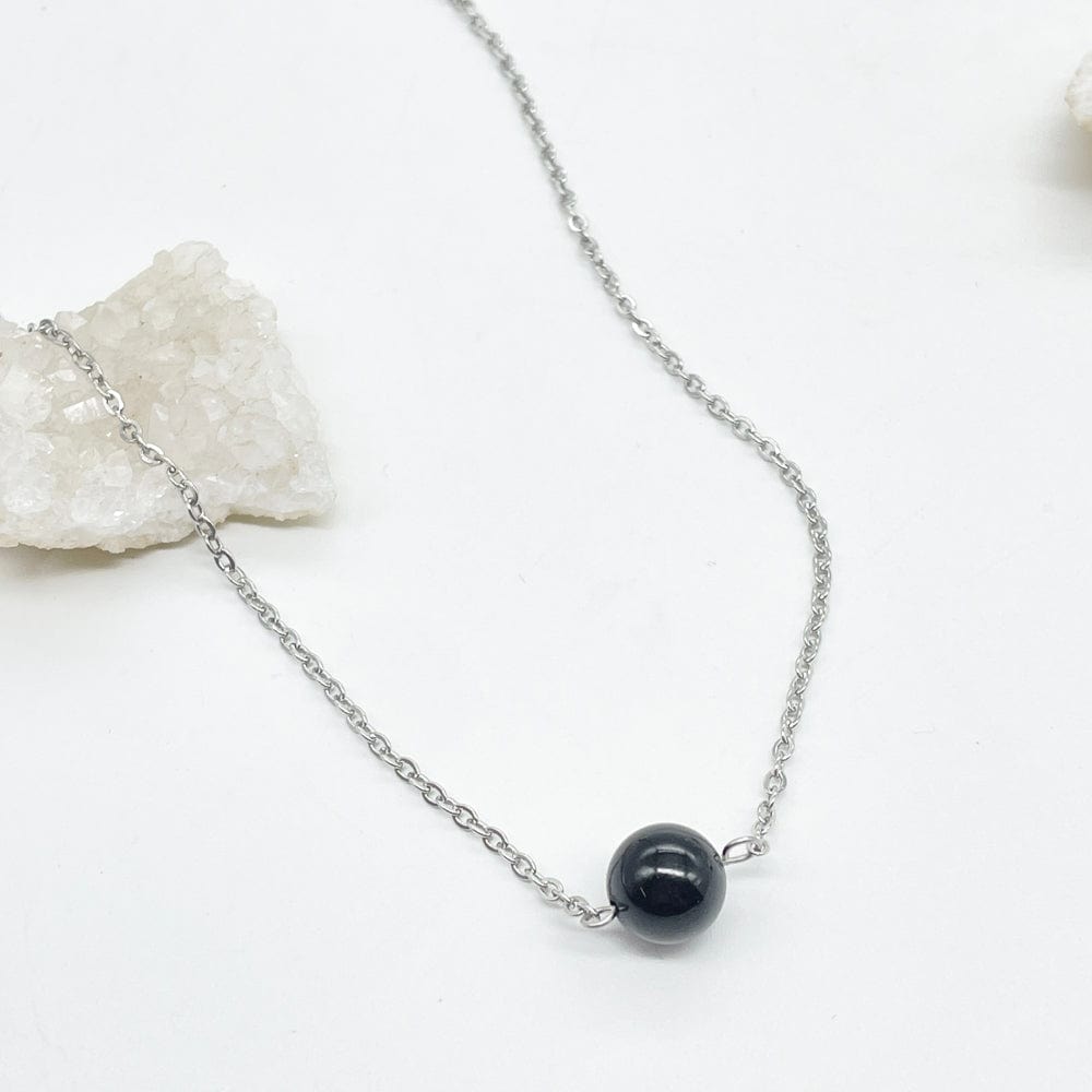 Collar finito plateado con cadena y un trozo natural de turmalina negra, la piedra de la protección