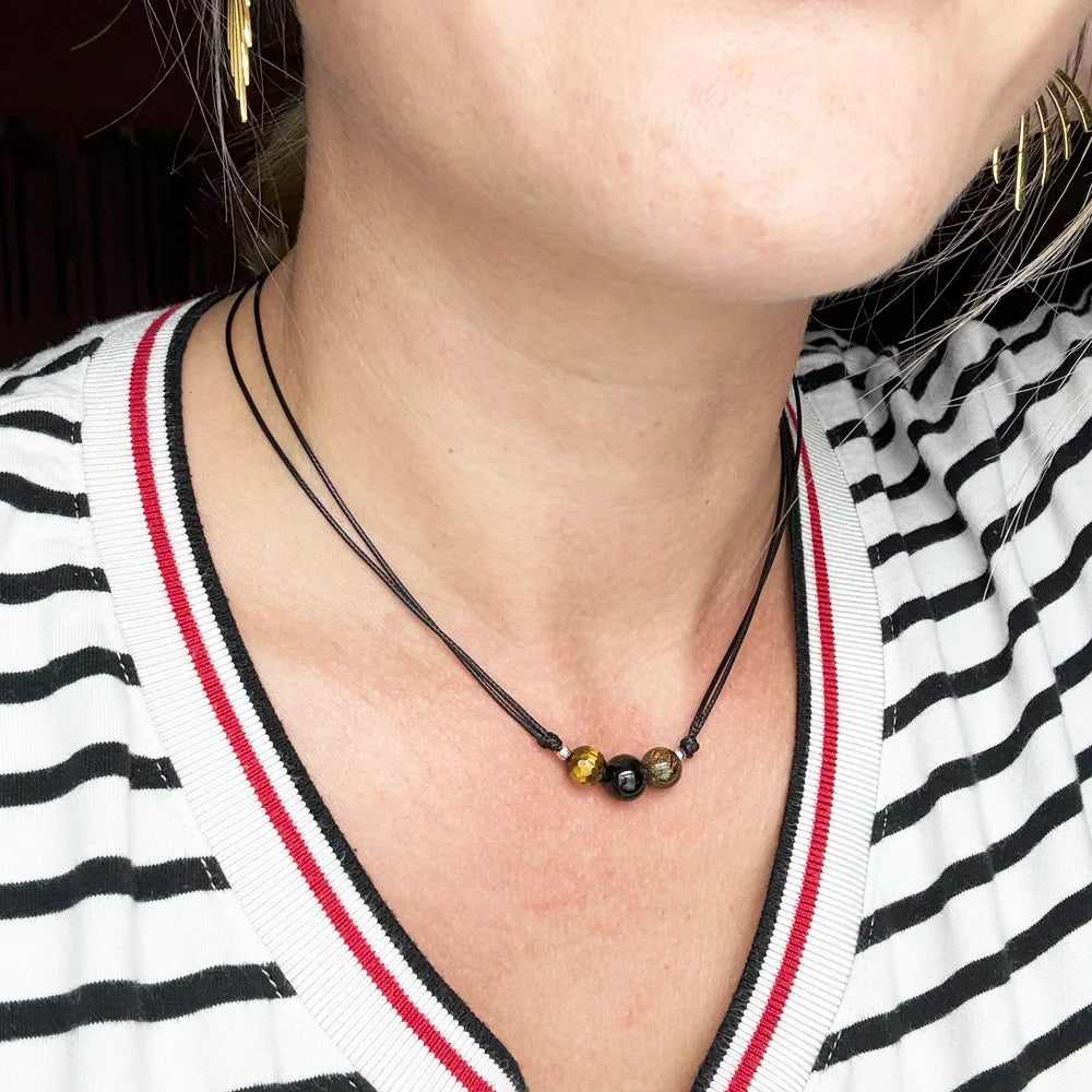 Detalle del collar de protección: ojo de tigre, turmalina negra y broncita