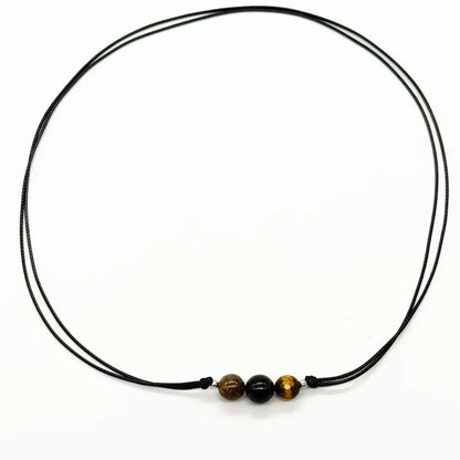 Collar de protección unisex en cordón negro con ojo de tigre, turmalina negra y broncita