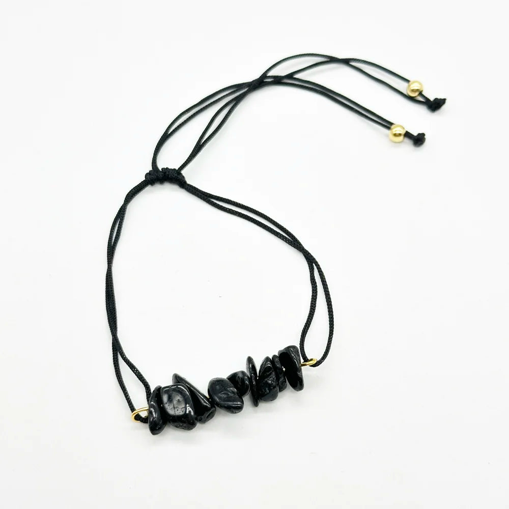 Detalle de pulsera de hilo negro con trocitos de turmalina negra