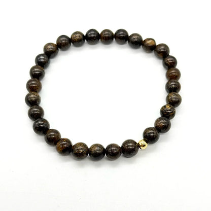 Pulsera elástica de broncita natural sobre fondo blanco